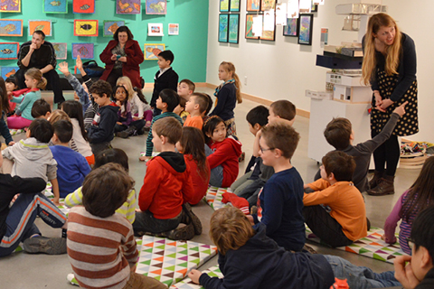 Young people gathered in the ArtStarts Gallery sitting on mats