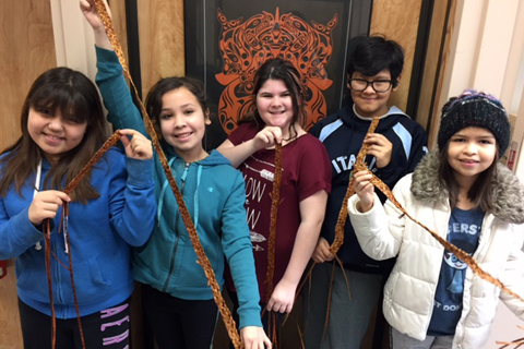 A group of young people posing with woven belts